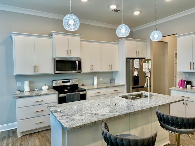 kitchen featuring white cabinetry, stainless steel appliances, sink, and a breakfast bar area