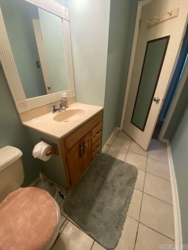 bathroom featuring tile patterned floors, vanity, and toilet