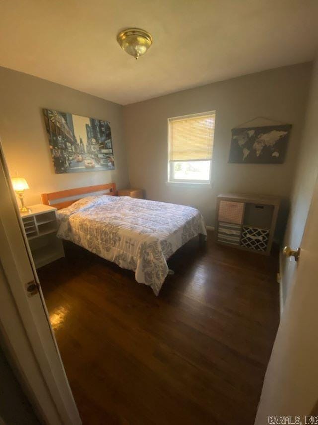 bedroom with dark hardwood / wood-style floors