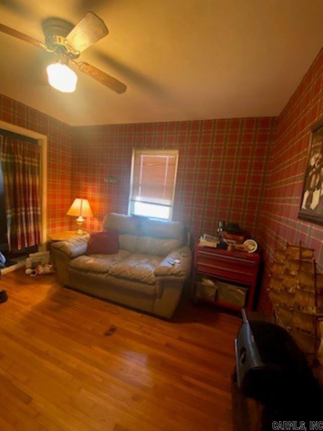 living room featuring ceiling fan and hardwood / wood-style floors