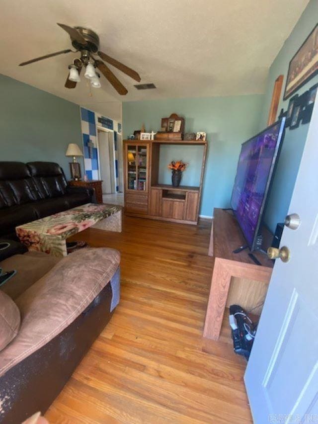 living room with ceiling fan and light hardwood / wood-style flooring