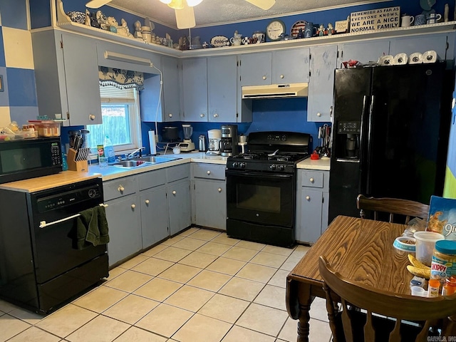 kitchen featuring black appliances, sink, ceiling fan, light tile patterned floors, and a textured ceiling