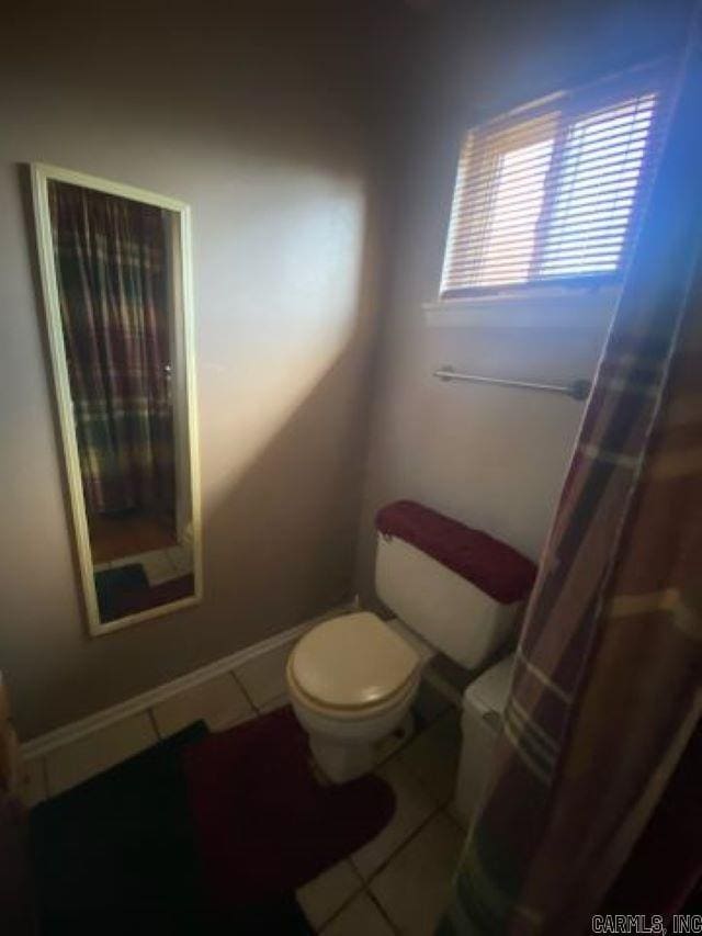 bathroom with toilet and tile patterned floors