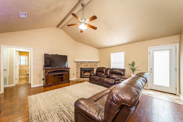 living room with a fireplace, lofted ceiling with beams, a textured ceiling, dark hardwood / wood-style flooring, and ceiling fan