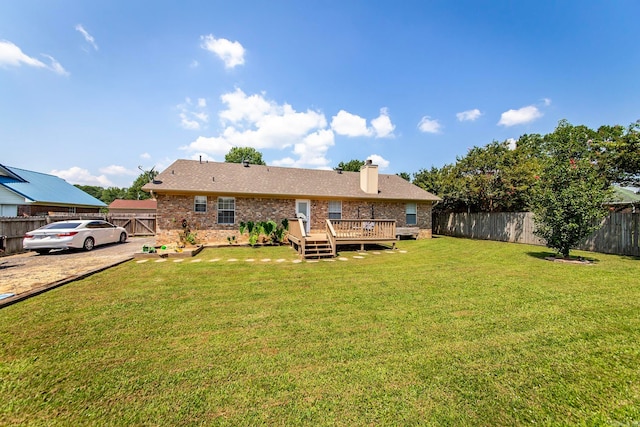 back of property with a yard and a deck