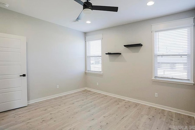 empty room featuring light hardwood / wood-style flooring, a wealth of natural light, and ceiling fan