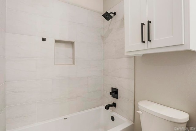 bathroom featuring tiled shower / bath combo and toilet