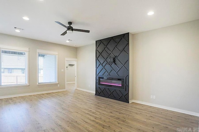 unfurnished living room featuring light hardwood / wood-style floors, a fireplace, and ceiling fan