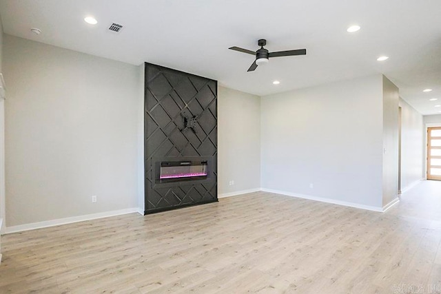 unfurnished living room with light hardwood / wood-style floors, a fireplace, and ceiling fan