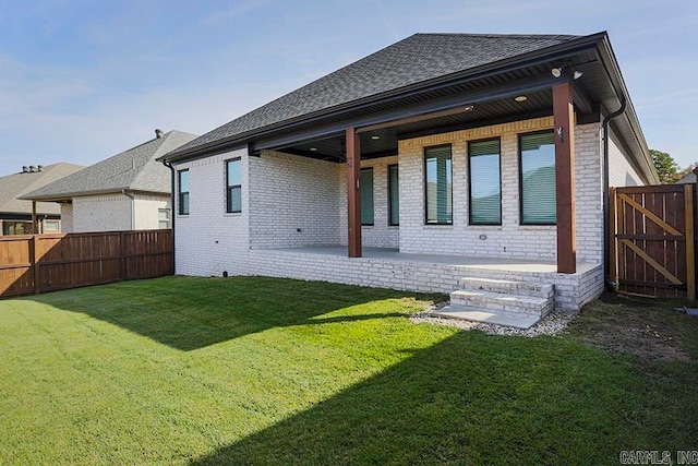 back of house with a patio area and a yard