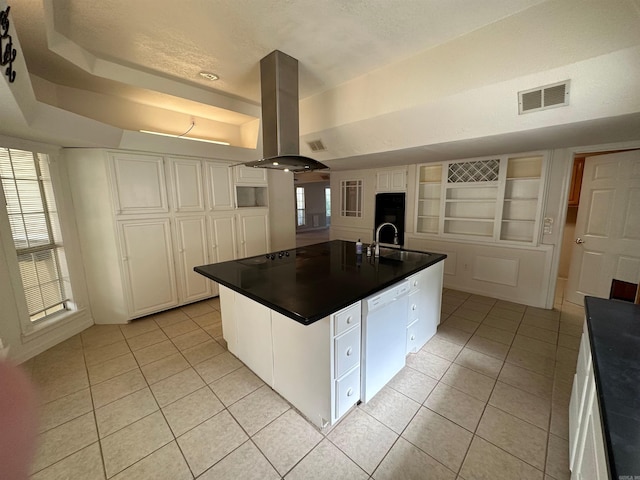 kitchen with island exhaust hood, an island with sink, white dishwasher, light tile patterned floors, and white cabinetry