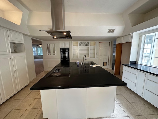 kitchen featuring island exhaust hood, a kitchen island with sink, and white cabinets