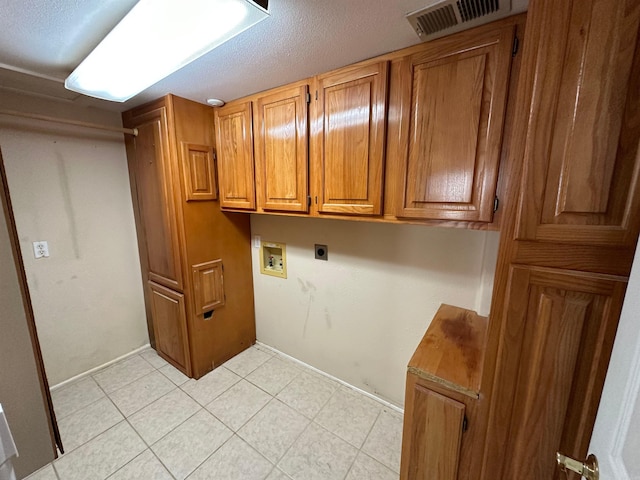 washroom with electric dryer hookup, washer hookup, and cabinets