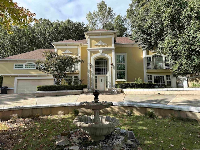 mediterranean / spanish home featuring a garage and a balcony