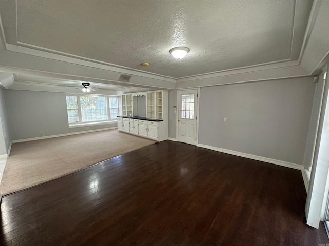 interior space with ceiling fan, a healthy amount of sunlight, a textured ceiling, and dark hardwood / wood-style flooring