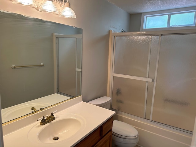 full bathroom with toilet, a textured ceiling, vanity, and enclosed tub / shower combo