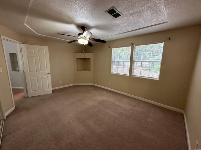 carpeted spare room featuring a textured ceiling and ceiling fan