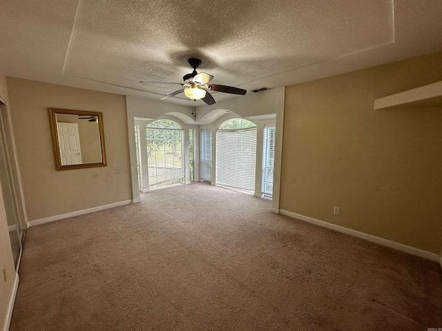 carpeted empty room with a textured ceiling and ceiling fan