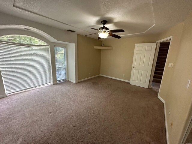 spare room with carpet, a textured ceiling, and ceiling fan