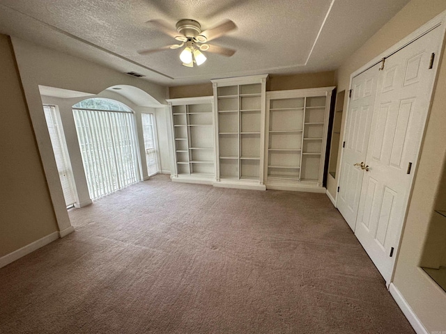 unfurnished living room featuring a textured ceiling, carpet flooring, and ceiling fan