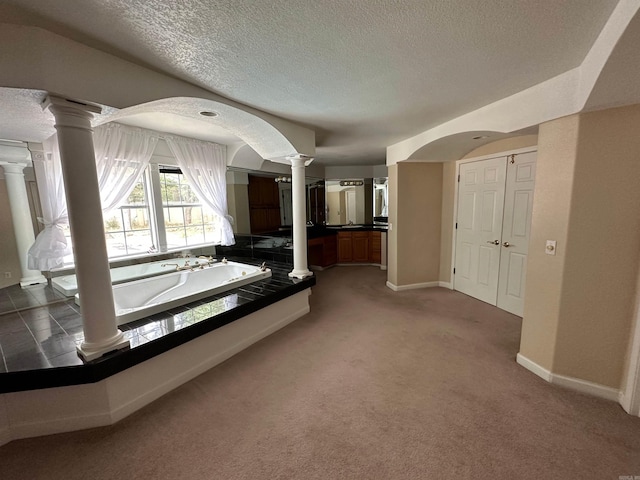 unfurnished bedroom featuring ornate columns, carpet flooring, and a textured ceiling