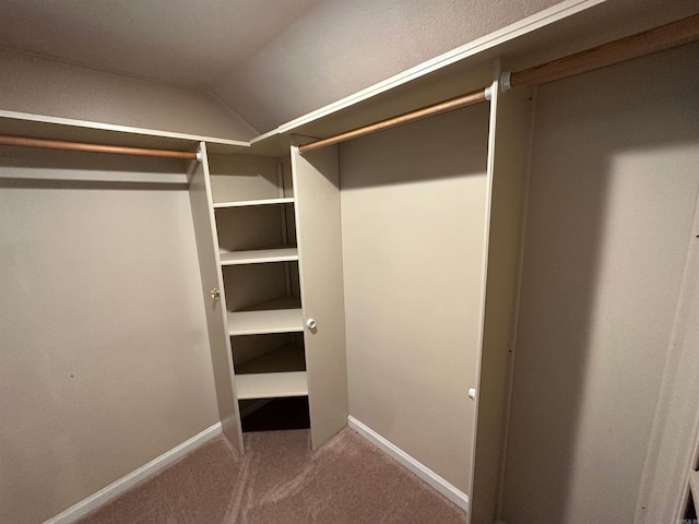 spacious closet featuring carpet flooring and vaulted ceiling