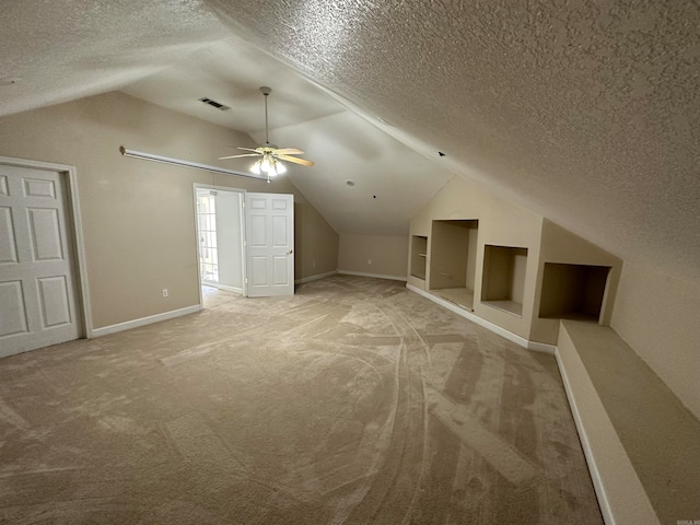 bonus room with lofted ceiling, carpet, a textured ceiling, and ceiling fan