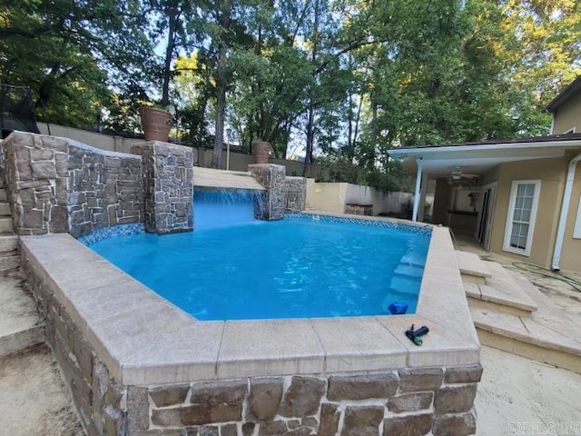 view of swimming pool featuring pool water feature and a patio