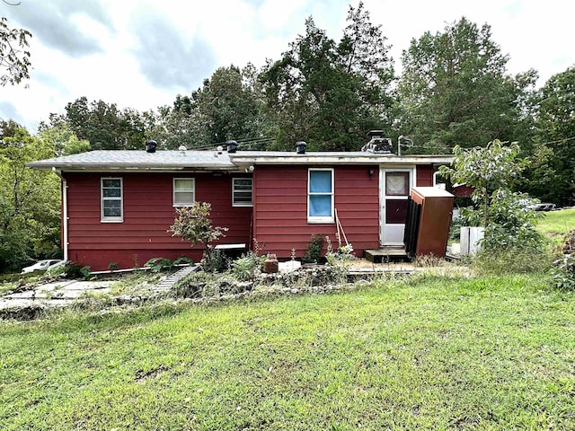 rear view of property featuring a yard