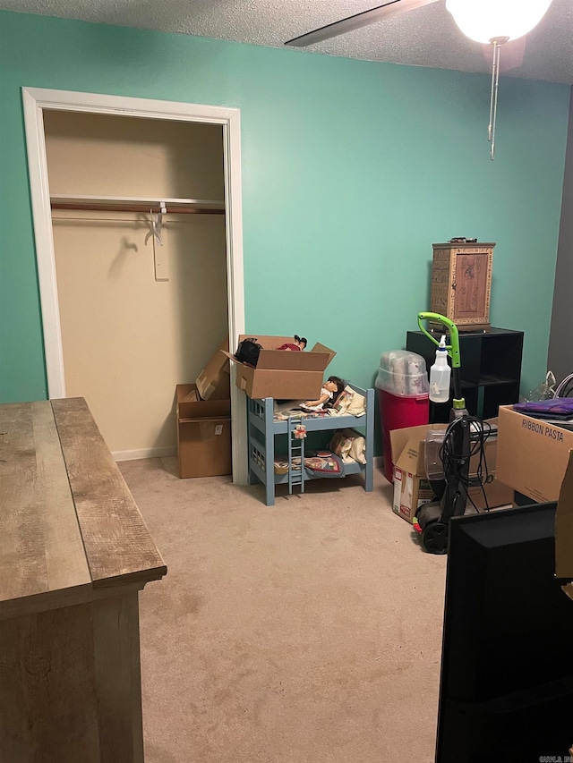 carpeted bedroom featuring a closet, ceiling fan, and a textured ceiling