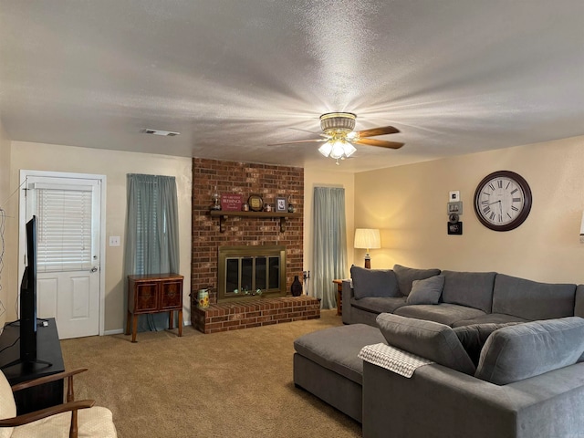 carpeted living room with ceiling fan, a textured ceiling, and a fireplace