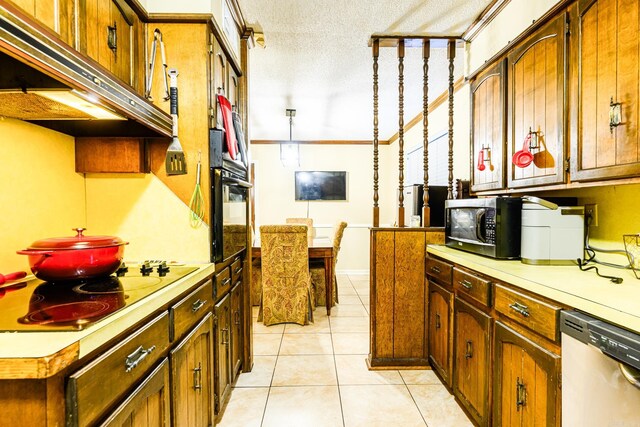 kitchen featuring a textured ceiling, stainless steel appliances, and light tile patterned floors