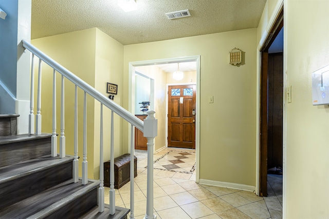 tiled entrance foyer with a textured ceiling