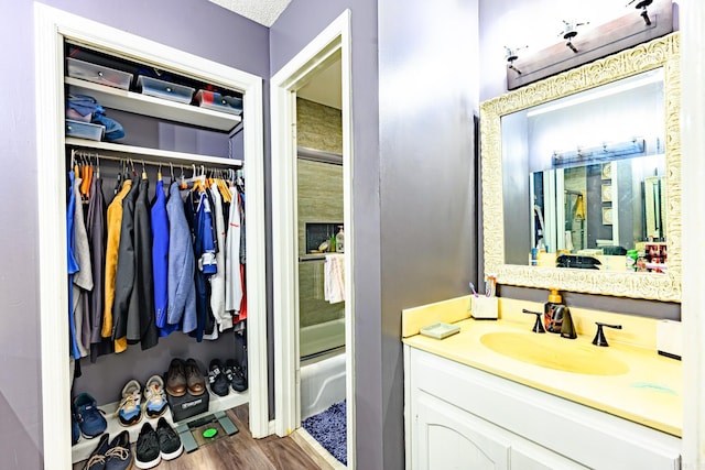 bathroom featuring vanity, bath / shower combo with glass door, and hardwood / wood-style flooring