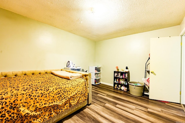 bedroom featuring hardwood / wood-style flooring and a textured ceiling