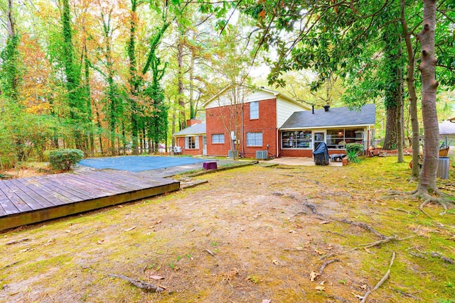 rear view of property with a patio area, central AC unit, and a sunroom