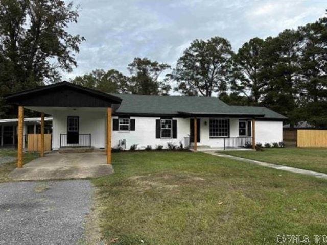 ranch-style home with a front lawn and a carport