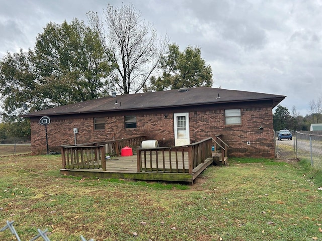 rear view of property with a lawn and a deck