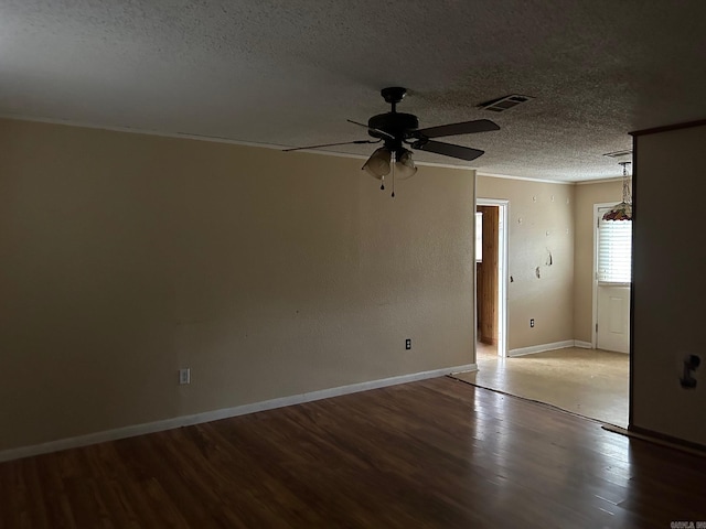 empty room featuring ornamental molding, wood-type flooring, ceiling fan, and a textured ceiling