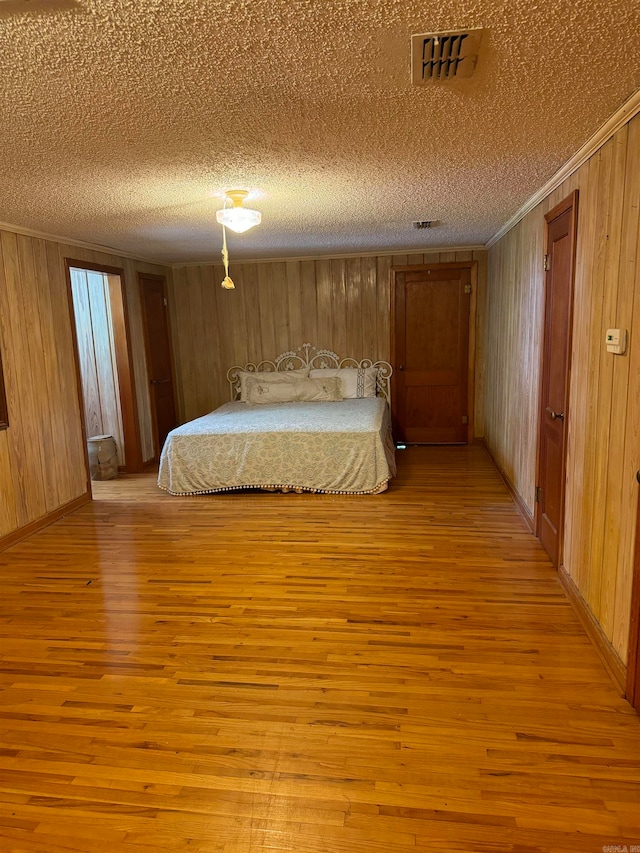 unfurnished bedroom featuring light hardwood / wood-style floors and wood walls