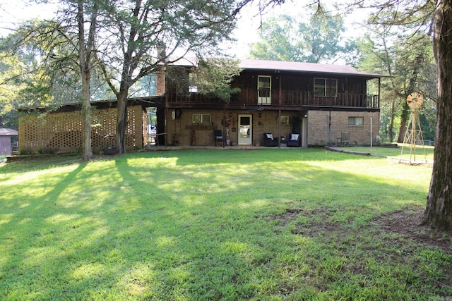 rear view of property with a balcony and a yard