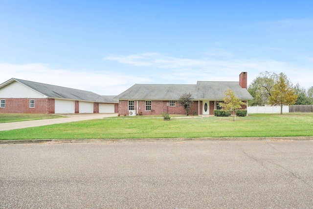 single story home featuring a garage and a front lawn