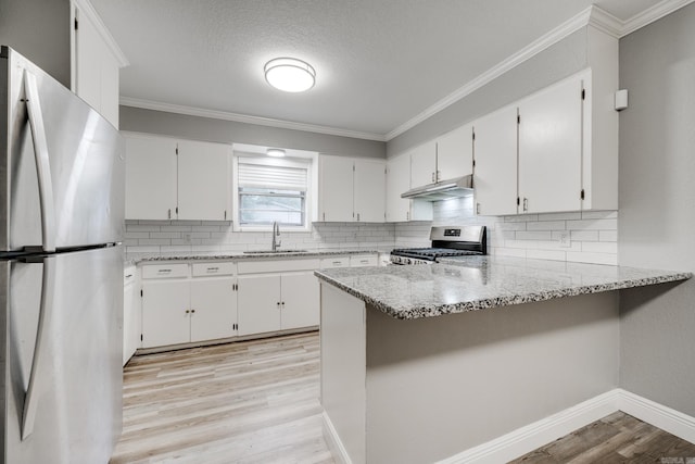 kitchen featuring white cabinets, kitchen peninsula, and appliances with stainless steel finishes