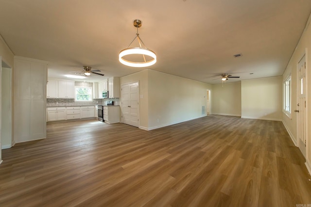 unfurnished living room featuring hardwood / wood-style flooring and ceiling fan