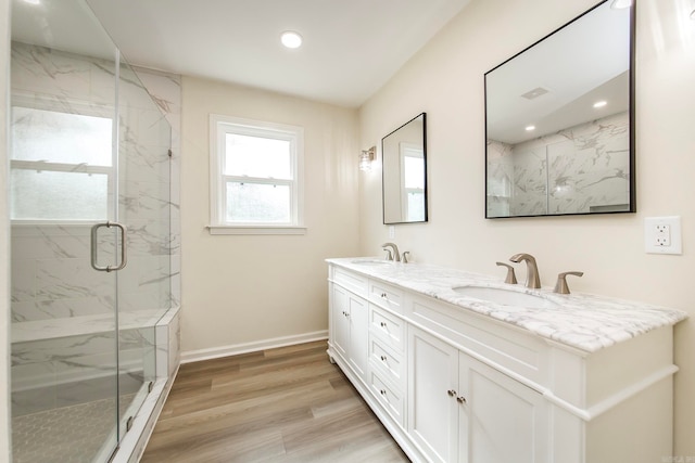 bathroom with wood-type flooring, vanity, and a shower with shower door