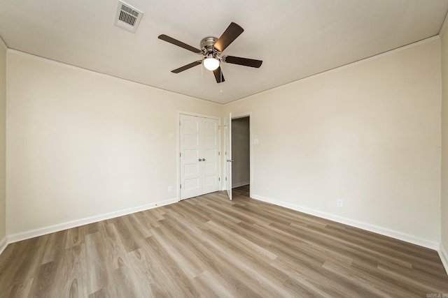 empty room with ceiling fan and light hardwood / wood-style flooring