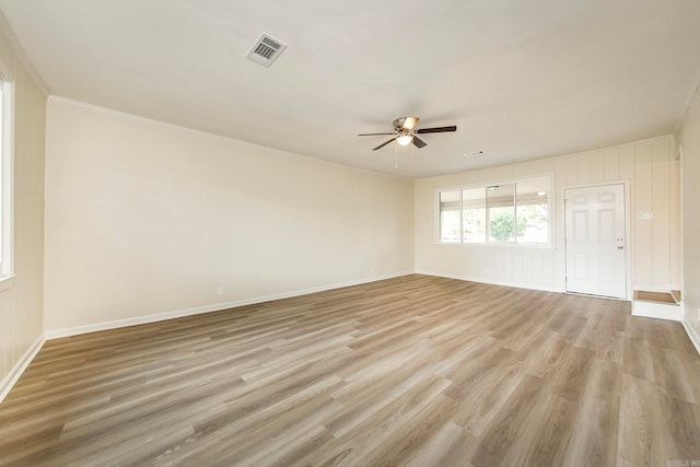 empty room with ornamental molding, light hardwood / wood-style flooring, and ceiling fan