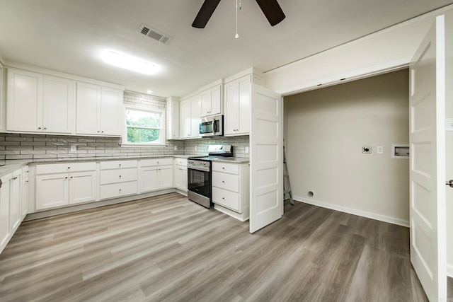 kitchen with light hardwood / wood-style flooring, tasteful backsplash, ceiling fan, white cabinetry, and appliances with stainless steel finishes