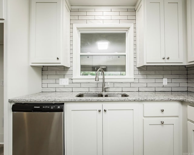 kitchen featuring stainless steel dishwasher, white cabinetry, and sink