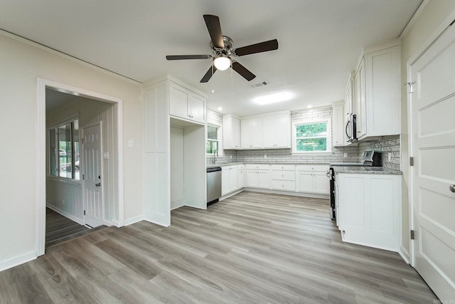 kitchen featuring light hardwood / wood-style flooring, white cabinetry, light stone countertops, and stainless steel appliances